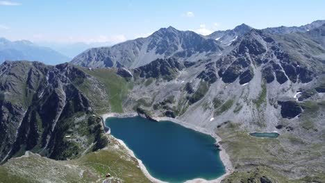 Idílico-Lago-De-Montaña-De-Color-Azul-Profundo-En-Medio-De-Los-Alpes-Suizos-Con-Cielos-Soleados