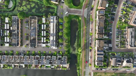Luftaufnahme-Einer-Stadtlandschaft-Mit-Reihen-Neuer-Häuser,-Vermischt-Mit-Einer-Wasserstraße-Und-Straßen-Aus-Der-Vogelperspektive