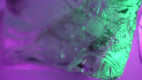 Macro,-abstract-background,-transition-or-overlay-layer-as-purple-and-green-lights-pass-through-a-rotating-crystal