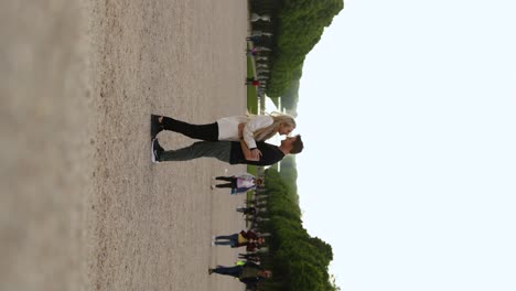 Couple-Kissing-on-Romantic-France-Honeymoon-in-Versailles-Garden,-Vertical