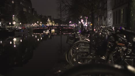 Canal-De-Amsterdam-Con-Bicicletas-En-Primer-Plano-Por-La-Noche-En-Los-Países-Bajos-En-Los-Fríos-Canales-De-Invierno