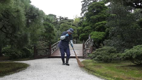 Japanese-gardener-cleaning-up-the-stunning-garden-of-Kyoto,-Japan