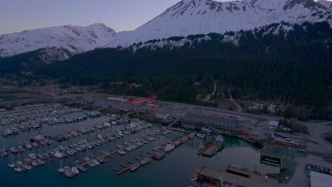 Sunrise-flyover-of-Seward-Boat-Harbor-towards-mountains-and-Harbor-360-Hotel-in-Seward-Alaska