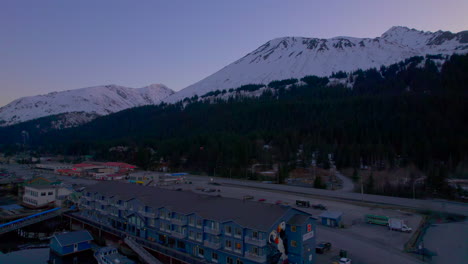 Drone-rising-up-view-of-Harbor-360-Hotel-and-mountains-at-sunset-in-Seward-Alaska