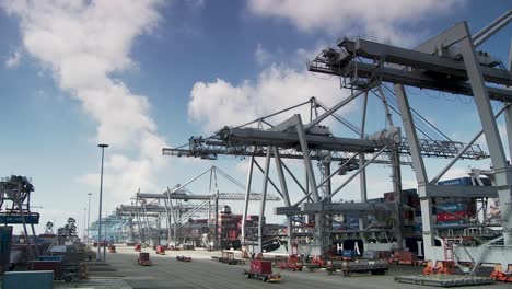 Cranes,-self-driving-truck-and-container-ships-at-Rotterdam-cargo-port,-panorama