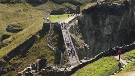 Timelapse-shot-of-tourists-crossing-the-iconic-Tintagel-Castle-Bridge-in-Tintagel