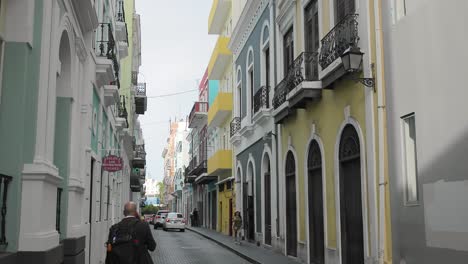 Blick-Auf-Die-Straße-Der-Altstadt-Von-San-Juan,-Puerto-Rico,-Mit-Fußgängern-Und-Wenig-Verkehr-In-Engen-Kopfsteinpflasterstraßen-–-Handheld
