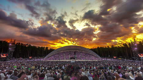 Timelapse-of-rolling-clouds-and-an-epic-fiery-sky-over-stage-at-Latvian-Song-and-Dance-Festival,-Riga-City