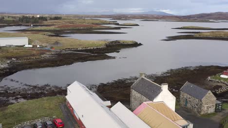 Reversing-drone-shot-of-the-Taigh-Chearsabhagh-Museum-and-Arts-Centre,-and-the-moor-and-peatland-surrounding-Lochmaddy-on-the-island-of-North-Uist,-part-of-the-Outer-Hebrides-of-Scotland
