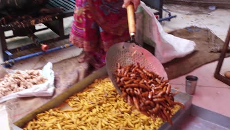 A-woman-is-frying-turmeric-and-ginger-in-ghee-and-separating-the-fried-ginger-from-which-it-will-be-made-into-a-powder