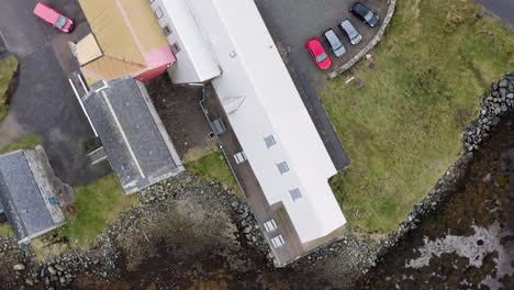 Dynamic,-birds-eye-view-drone-shot-of-the-Taigh-Chearsabhagh-Museum-and-Arts-Centre-in-the-village-of-Lochmaddy-on-the-Isle-of-North-Uist,-part-of-the-Outer-Hebrides-of-Scotland