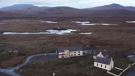 Static-drone-shot-of-the-Cnoc-Soilleir-building-in-South-Uist-and-the-surrounding-moor-and-peatland