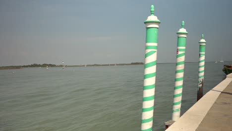 Green-and-white-striped-posts-on-the-dock-of-a-pier-mark-the-area-for-boats