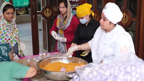 Many-women-in-Gurdwara-are-packing-turmeric-powder,-turmeric-and-ginger-powder-will-be-distributed-free-which-is-very-good-for-health