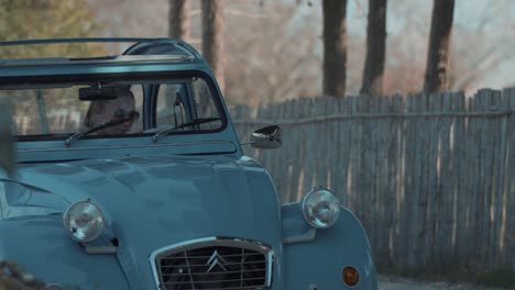 Slow-motion-shot-of-a-female-getting-in-the-driver's-seat-of-a-vintage-Deux-Chevaux