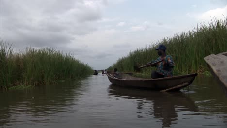 Fischer-Paddelt-Rückwärts-Auf-Einem-Fluss-In-Nigeria
