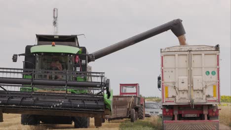 Slow-motion-clip-of-a-combine-harvester-dumping-grain-into-a-truck