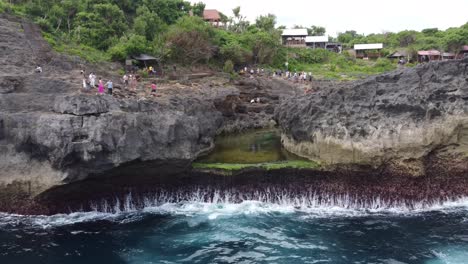 Tourists-flocking-to-Angel's-Billabong,-a-natural-tidal-rock-pool-formation-and-photo-spot-on-Nusa-Penida-Island,-Bali