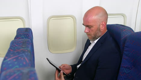 A-revealing-shot-of-a-man-on-a-plane-using-a-tablet-pc