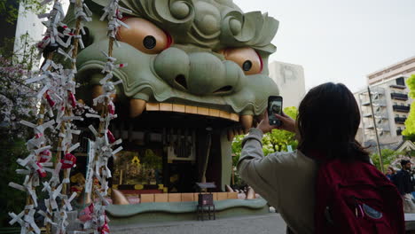 Slow-motion-shot-of-a-female-tourist-taking-photos-of-a-large-dragon-symbol