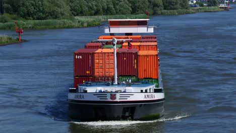 The-cargo-ship-Amira-approaches-the-town-of-Zwijndrecht,-gliding-through-the-waters