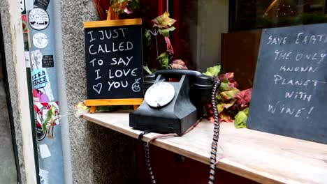 Walking-down-streets-of-Porto,-traditional-old-telephone-with-English-sign-decor