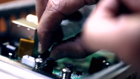 the-engineer-installing-capacitor-on-motherboard