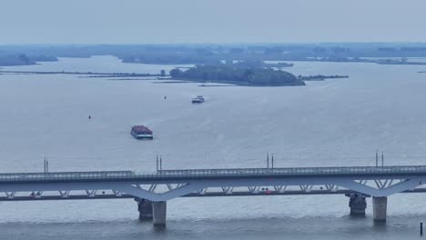 Panning-Aerial-Shot:-Moerdijk-Bridges-with-Cargo-Boats-and-Railway-Crossing