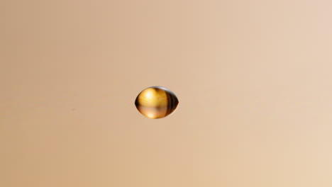 Golden-drop-of-water-on-the-surface---reflection,-abstract,-background,-overlay,-concept