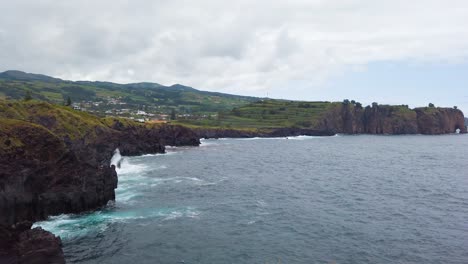Waves-at-the-volcanic-coastline-of-Capelas-filmed-from-the-lookout-of-Miradouro-das-Pedras-Negras,-Sao-Miguel-Island,-Azores,-Portugal