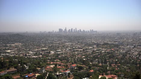 Panning-down-view-of-the-LA-skyline-from-the-Griffith-Observatory-with-blue-sky-and-lots-of-houses-and-neighborhoods