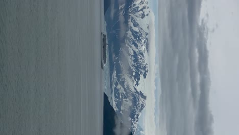 A-cruise-ship-sailing-close-to-Hubbard-Glacier-in-Disenchantment-Bay,-Alaska---vertical-orientation