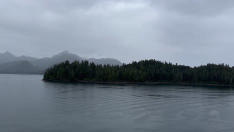 Eine-Bewaldete-Insel-Oder-Halbinsel-An-Der-Küste-Alaskas,-Von-Einem-Schiff-Auf-Dem-Fjord-Aus-Gesehen