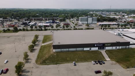 A-4K-Twirl-Aerial-Cinematic-Drone-Shot-of-Busy-City-18th-Street-Downtown-Westoba-Place-Keystone-Center-Stadium-Wheat-Kings-Hockey-Arena-in-Prairies-Town-Brandon-Manitoba-Canada
