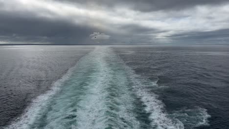 The-wake-behind-a-cruise-ship-in-on-a-cold,-cloudy,-moody-day-at-sea