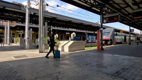 Passagier-Schiebt-Rollgepäck-über-Den-Bahnsteig-Zum-Zug-In-Bologna-Centrale