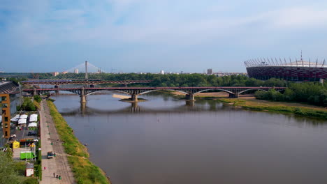 Aerial-pullback-over-Vistula-River-show-bridges-and-PGE-Narodowy-stadium