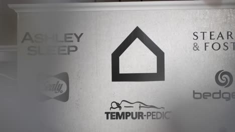 A-large-grey-logo-icon-wall-of-mattress-Tempur-Pedic-Bedgear-Stearns-Foster-Sealy-inside-the-Chicago-Ashley-Furniture-Industry-HomeStore