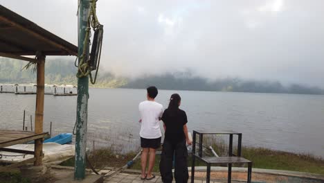 Pareja-Joven-Romántica-Mirando-El-Lago-Nublado-Ratan-En-Bedugul-Bali-Indonesia