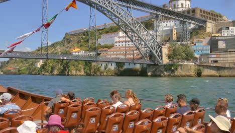 Slow-tilt-down,-showing-the-famous-Dom-Luis-I-Bridge-in-Porto,-connecting-the-two-sides-of-the-city-over-the-Douro-river-known-for-Port-Wine