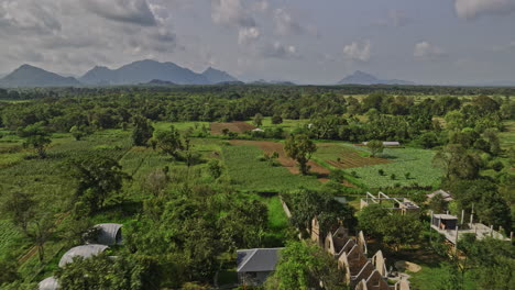 Sigiriya-Sri-Lanka-Aerial-v3-low-drone-flyover-secluded-resort-hotels-surrounded-by-lush-green-environment-and-agricultural-farmlands-and-mountain-landscape---Shot-with-Mavic-3-Cine---April-2023