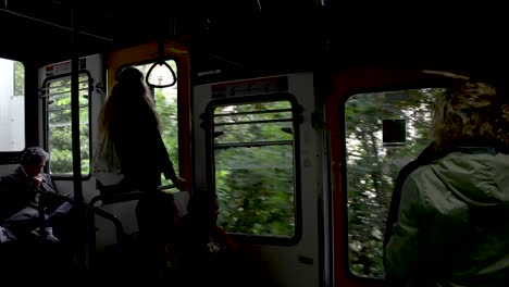 Passengers-Inside-Funicular-Travelling-Past-Trees-In-Naples