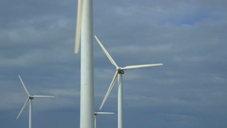 Windturbinen-Mit-Blick-Auf-Den-Parallaxenstapel-An-Einem-Hellen,-Bewölkten,-Windigen-Sommertag