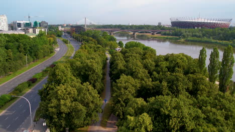 Aerial-over-green-Vistula-River-bank-in-Warsaw,-view-of-PGE-Narodowy-stadium