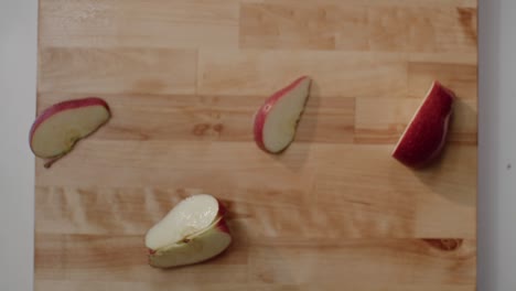 Manzana-Roja-Deliciosa-Cayendo-Sobre-La-Tabla-De-Cortar-Y-Cayendo-En-Rodajas