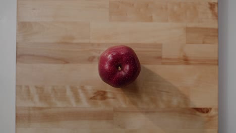 Una-Manzana-Roja-Deliciosa-Sentada-En-Una-Tabla-De-Cortar