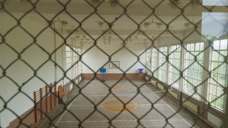 Desolate-Bulgarian-school-gym-elevated-view-behind-wire-mesh-slide-shot