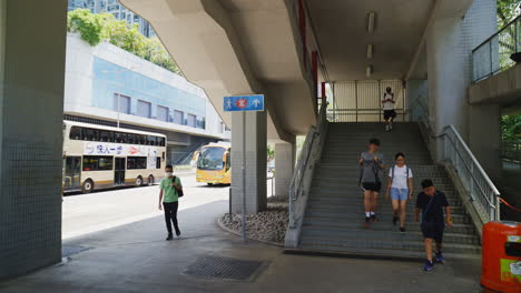 Asiatische-Menschen,-Die-Im-Sommer-Von-Der-Brücke-In-Der-Innenstadt-Von-Hongkong-Die-Treppe-Hinuntergehen-–-Orbitaufnahme