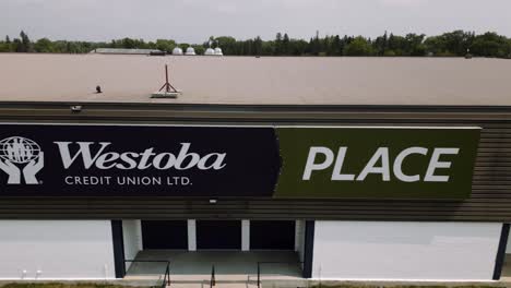 A-4K-logo-building-Aerial-Cinematic-Drone-Shot-of-Busy-City-18th-Street-Downtown-Westoba-Place-Keystone-Center-Stadium-Wheat-Kings-Hockey-Arena-in-Prairies-Town-Brandon-Manitoba-Canada