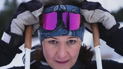Close-up-slow-motion-shot-of-female-skiier-pulling-down-goggles
